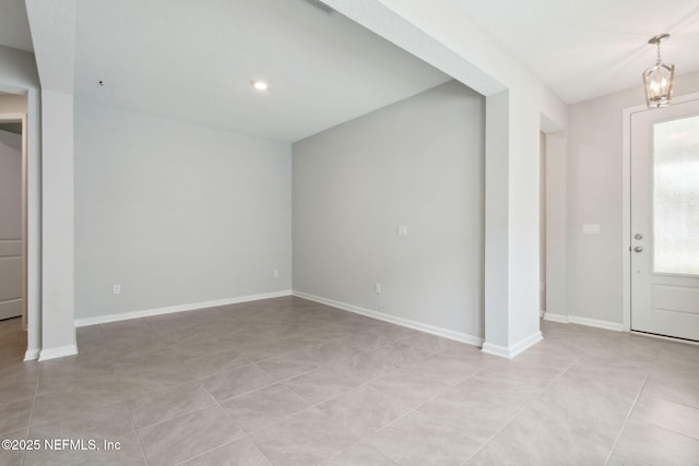 foyer entrance featuring a notable chandelier, baseboards, and light tile patterned floors