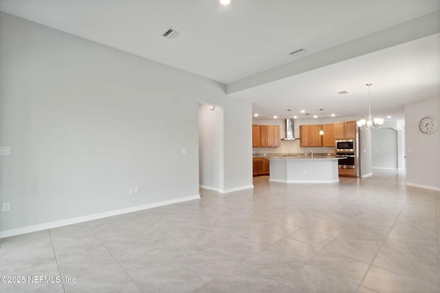 unfurnished living room with a chandelier, recessed lighting, visible vents, and baseboards