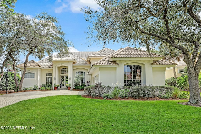 mediterranean / spanish home with a front lawn