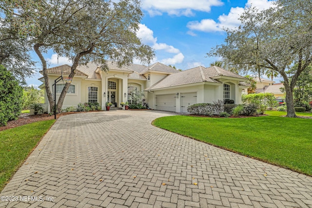 mediterranean / spanish-style house with a garage and a front yard