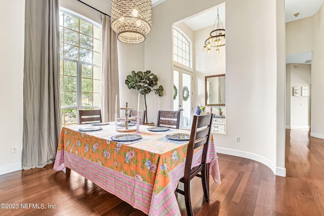 dining room featuring a high ceiling, hardwood / wood-style floors, and an inviting chandelier