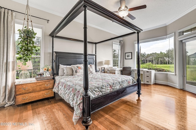 bedroom featuring ceiling fan, ornamental molding, and wood-type flooring