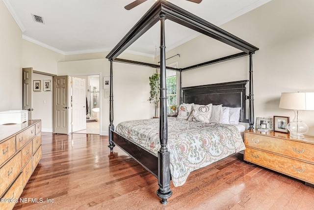 bedroom with hardwood / wood-style floors, ornamental molding, ceiling fan, and ensuite bath