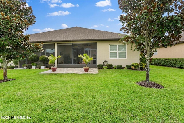 rear view of property featuring a sunroom, a patio area, and a yard