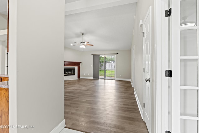 unfurnished living room featuring ceiling fan, hardwood / wood-style flooring, a textured ceiling, and lofted ceiling