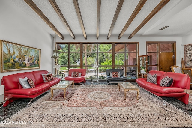 living room featuring a wealth of natural light, beam ceiling, and a textured ceiling