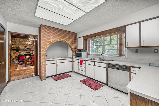 kitchen featuring light tile patterned flooring, sink, appliances with stainless steel finishes, a textured ceiling, and white cabinetry