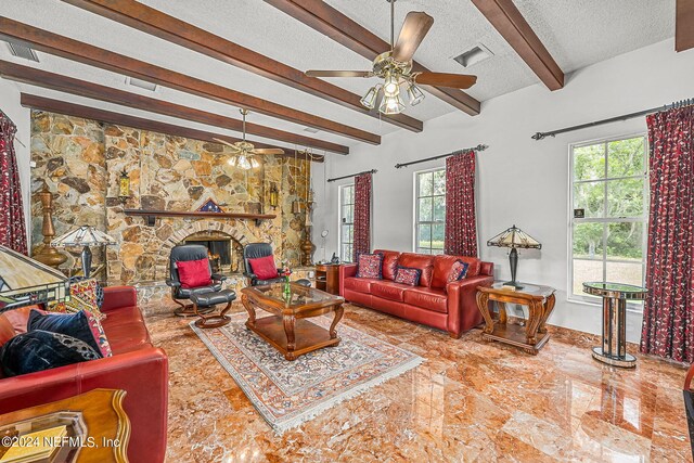 tiled living room with a textured ceiling, beam ceiling, ceiling fan, and a fireplace