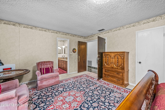 bedroom with light carpet, connected bathroom, and a textured ceiling