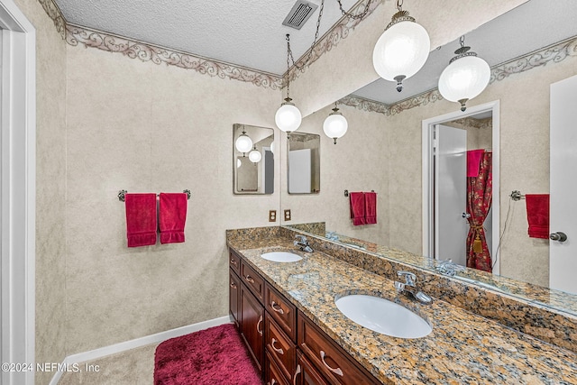 bathroom featuring a textured ceiling and vanity