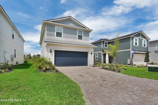 view of front of property with a garage, decorative driveway, a front lawn, and board and batten siding