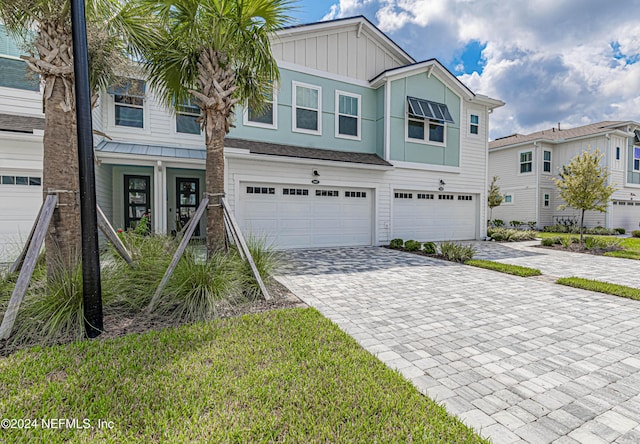 view of front of house featuring decorative driveway, an attached garage, and board and batten siding