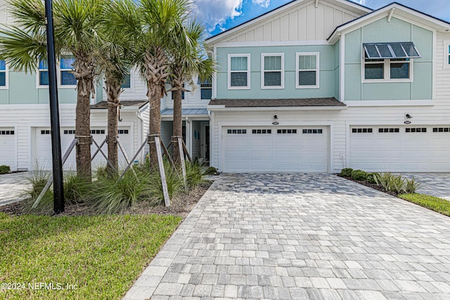 view of front of home with decorative driveway, a garage, and board and batten siding