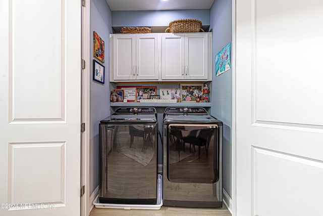 washroom with cabinet space, independent washer and dryer, and light wood-style floors
