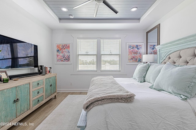 bedroom with a raised ceiling, baseboards, light wood-style floors, ceiling fan, and recessed lighting