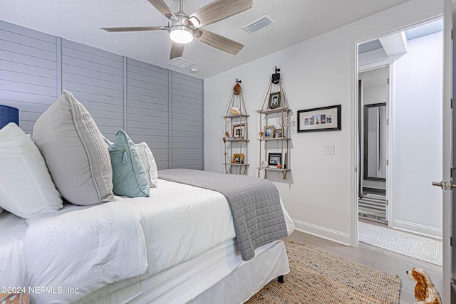bedroom featuring wood finished floors, a textured ceiling, ceiling fan, and visible vents