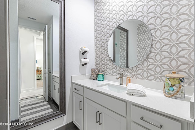 bathroom featuring a textured ceiling, visible vents, and vanity