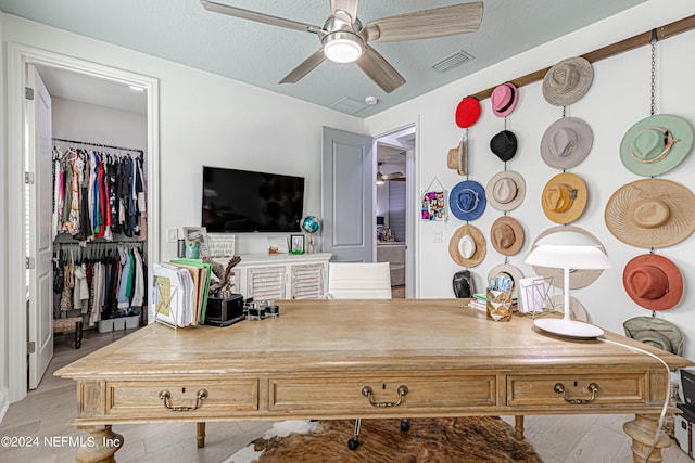 home office featuring a textured ceiling, ceiling fan, and visible vents