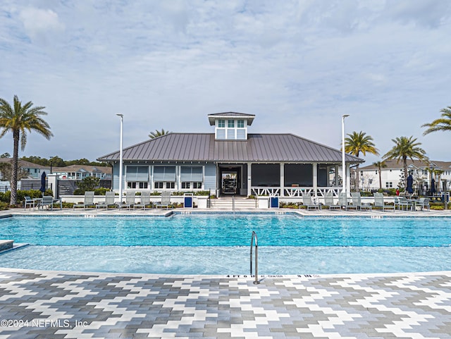 community pool with fence and a patio area