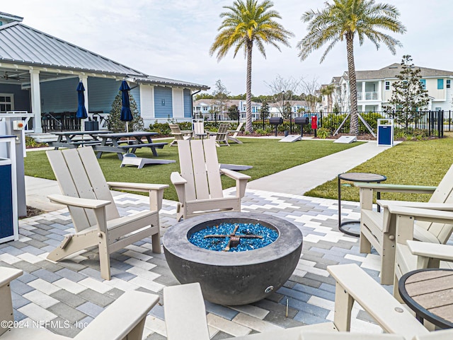 view of patio with an outdoor fire pit, a residential view, and fence