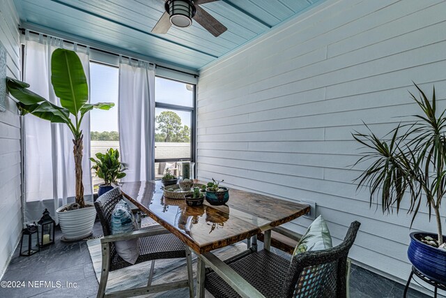 sunroom featuring a ceiling fan and outdoor dining space