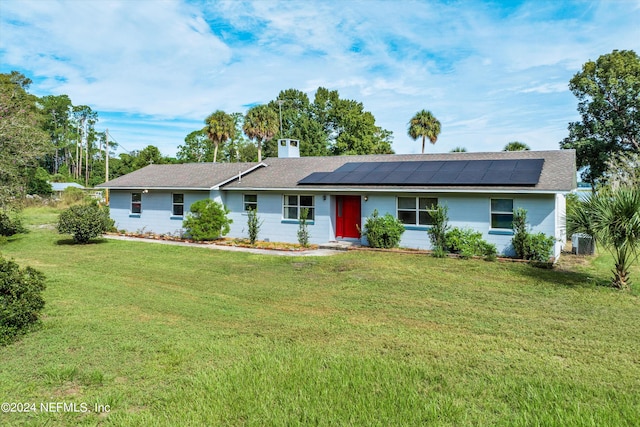 single story home featuring central AC, solar panels, and a front lawn