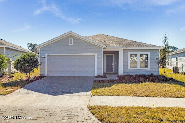 ranch-style home featuring central AC, a garage, and a front yard