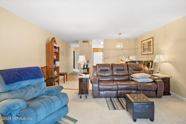 living area featuring light carpet, baseboards, visible vents, and a notable chandelier