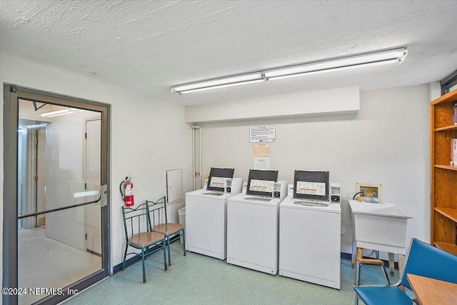 washroom featuring washing machine and dryer, a textured ceiling, and light tile patterned flooring