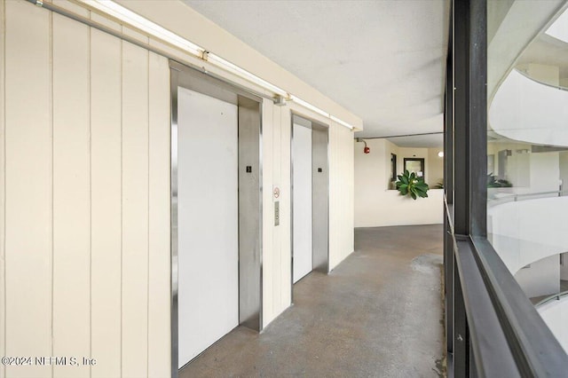 hallway featuring elevator and finished concrete floors