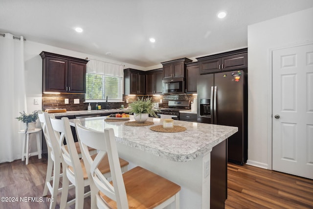 kitchen featuring appliances with stainless steel finishes, light countertops, backsplash, and dark brown cabinets