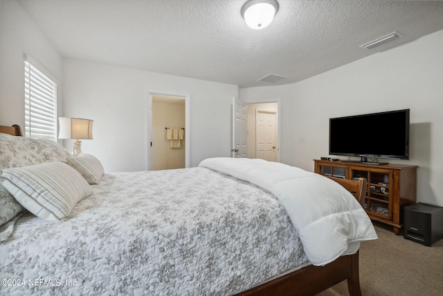 bedroom featuring a textured ceiling, carpet, and visible vents