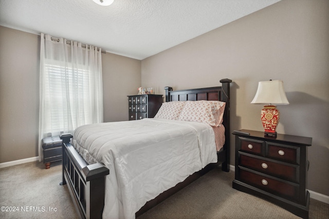 carpeted bedroom with a textured ceiling and baseboards