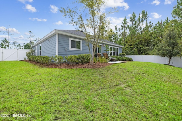 back of property with a yard, a patio, a fenced backyard, and a gate