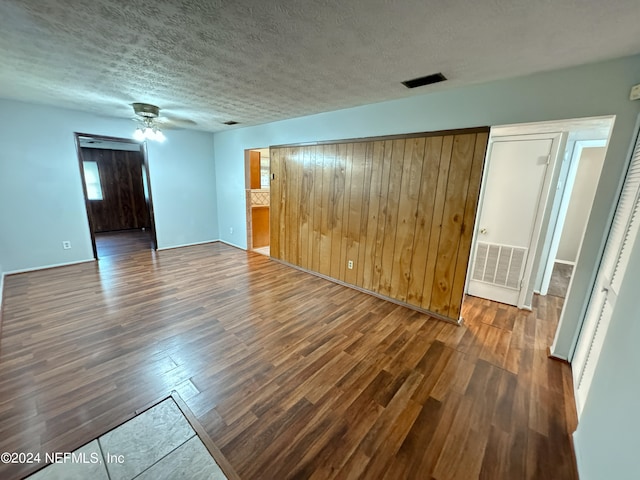 empty room featuring ceiling fan, dark hardwood / wood-style floors, and a textured ceiling