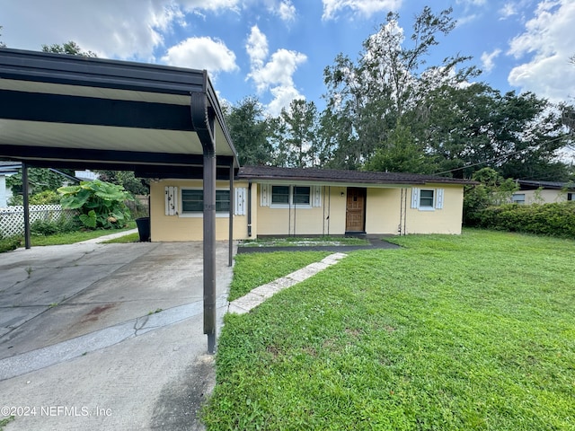 view of front of house featuring a front lawn and a carport