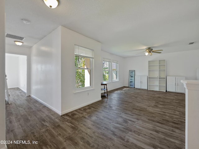 unfurnished living room with dark hardwood / wood-style flooring and ceiling fan