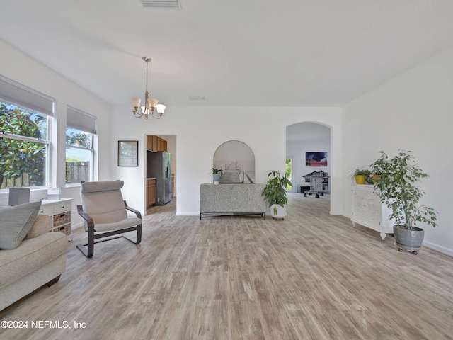 living room with an inviting chandelier and light hardwood / wood-style flooring