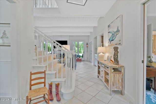 foyer entrance with beamed ceiling and light tile patterned flooring