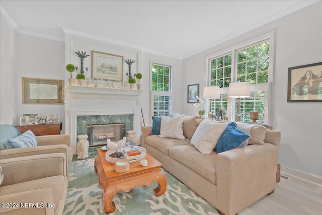 living room featuring crown molding, a high end fireplace, and light hardwood / wood-style floors