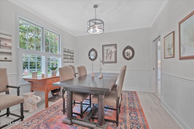 dining space with crown molding, a chandelier, and light hardwood / wood-style floors