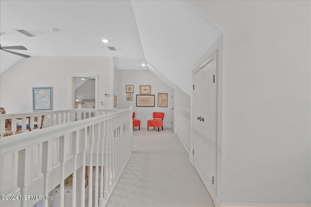 hallway featuring light carpet and lofted ceiling