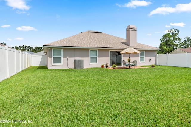 rear view of house featuring a yard, central AC, and a patio area