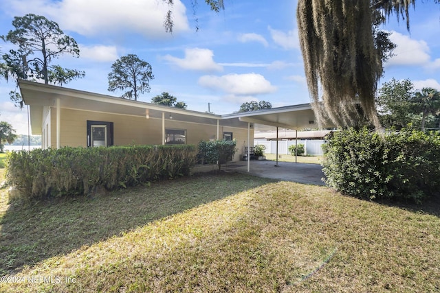 view of front of home featuring a front lawn and an attached carport