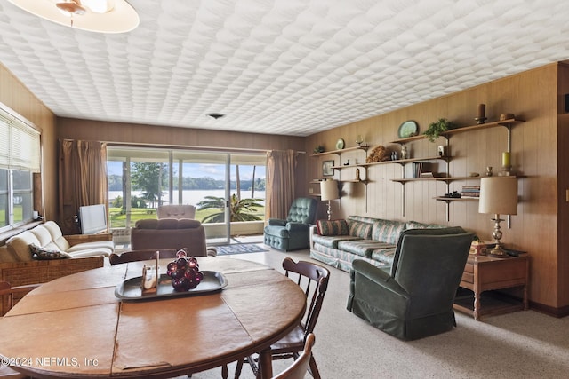 dining space with wood walls and a water view