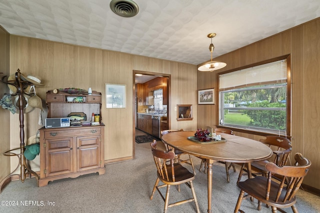 dining area featuring wooden walls and visible vents