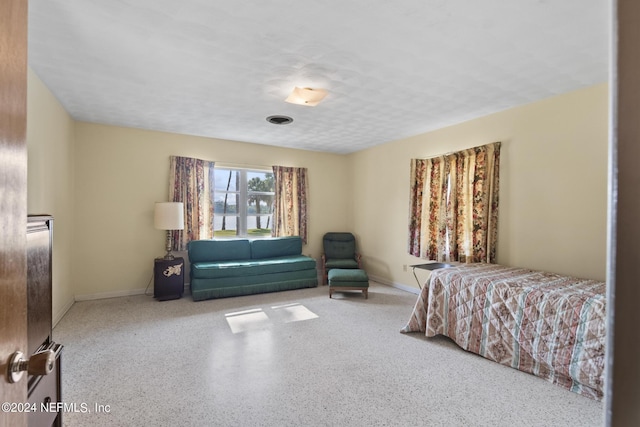 bedroom with light speckled floor, visible vents, and baseboards