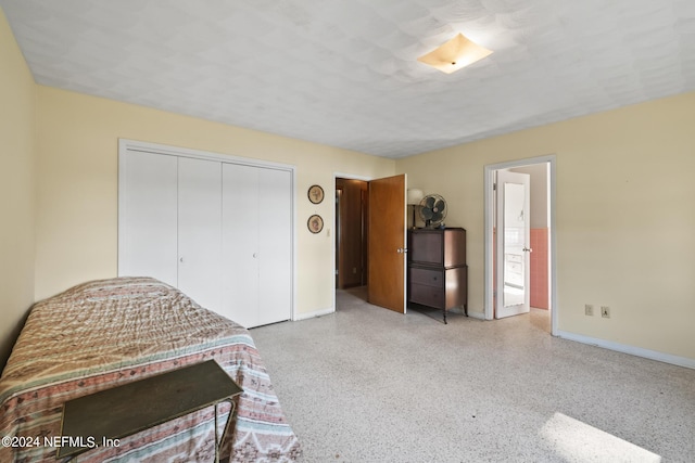 bedroom featuring baseboards, light speckled floor, and a closet