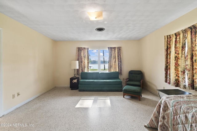 unfurnished room featuring baseboards, visible vents, and speckled floor