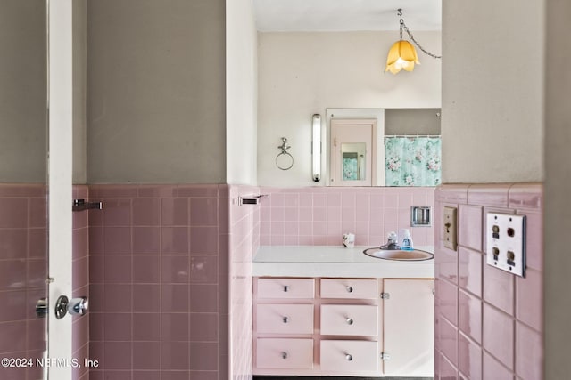 full bathroom with a wainscoted wall, tile walls, and vanity